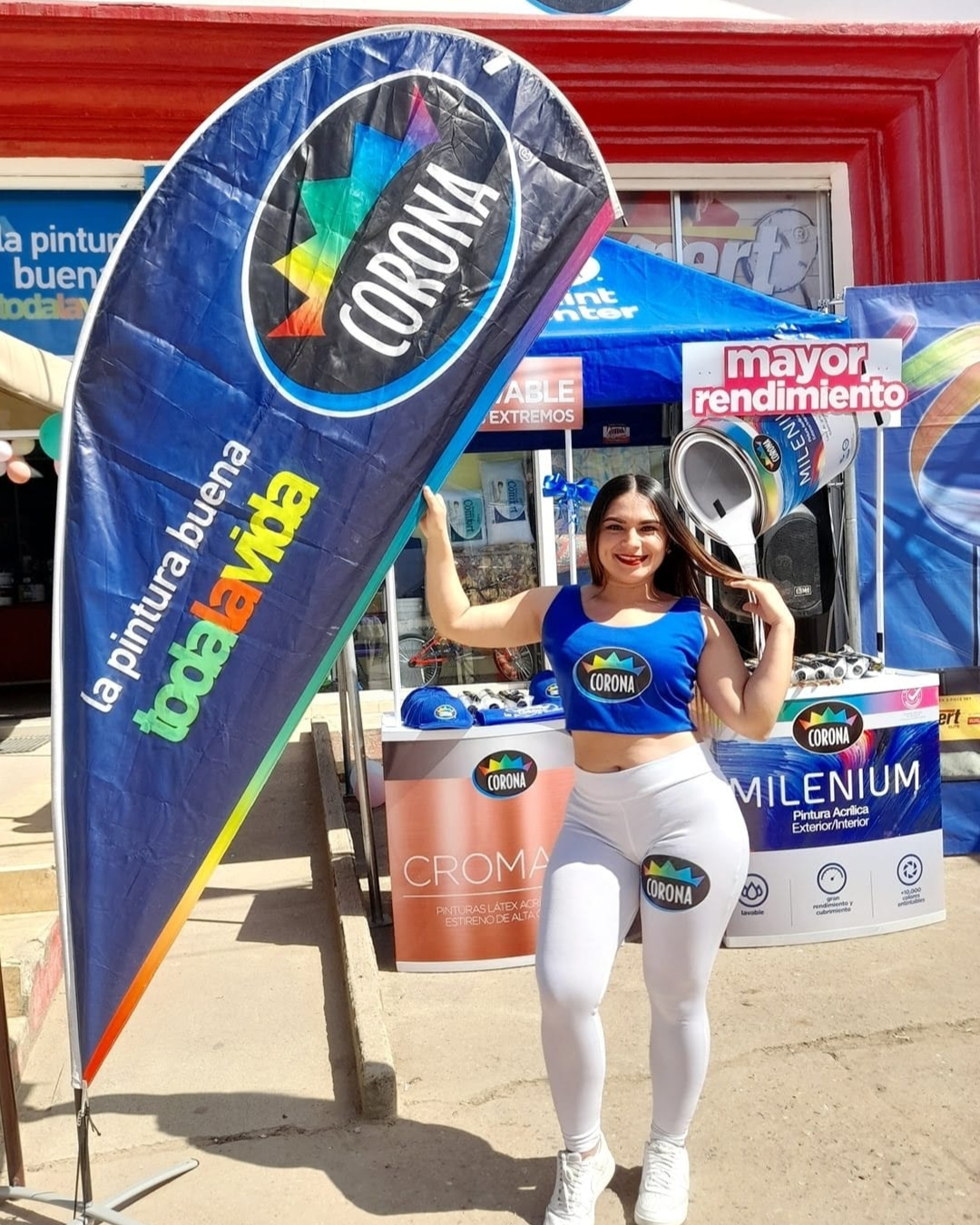 Promotora de marca Corona en exhibición comercial con material POP durante campaña presencial.