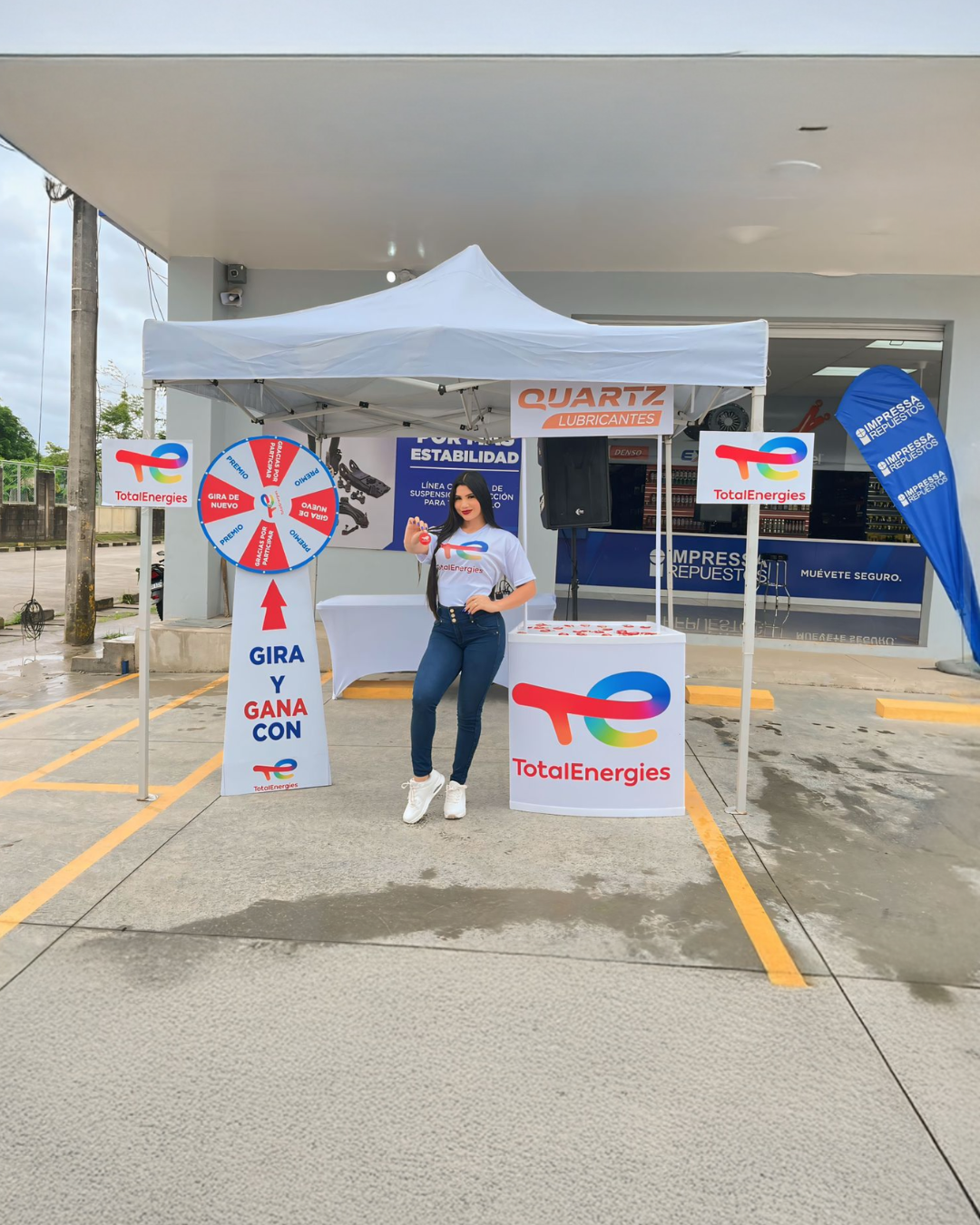 Promotora de marca Corona en exhibición comercial con material POP durante campaña presencial.