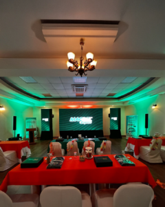Montaje de salón para evento corporativo BTL en Honduras con escenario, mesas promocionales y ambientación de marca
