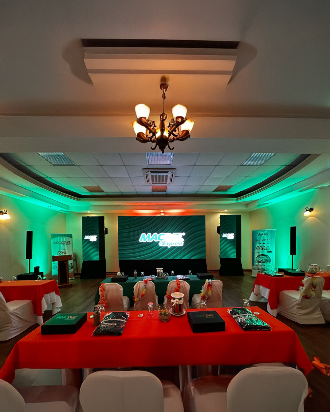 Montaje de salón para evento corporativo BTL en Honduras con escenario, mesas promocionales y ambientación de marca