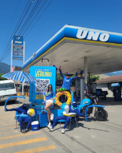 Personal realizando dinámica promocional de experiencia BTL en estación de servicio UNO con presencia comercial en punto de venta