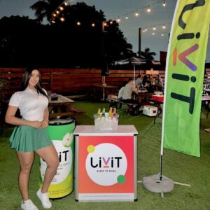 Activación BTL de Livit en Honduras con promotora, stand promocional, banderola publicitaria y exhibición de bebidas en evento al aire libre