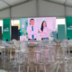Montaje de evento corporativo de Caja Rural en Honduras con pantalla principal, mobiliario transparente y ambientación de marca