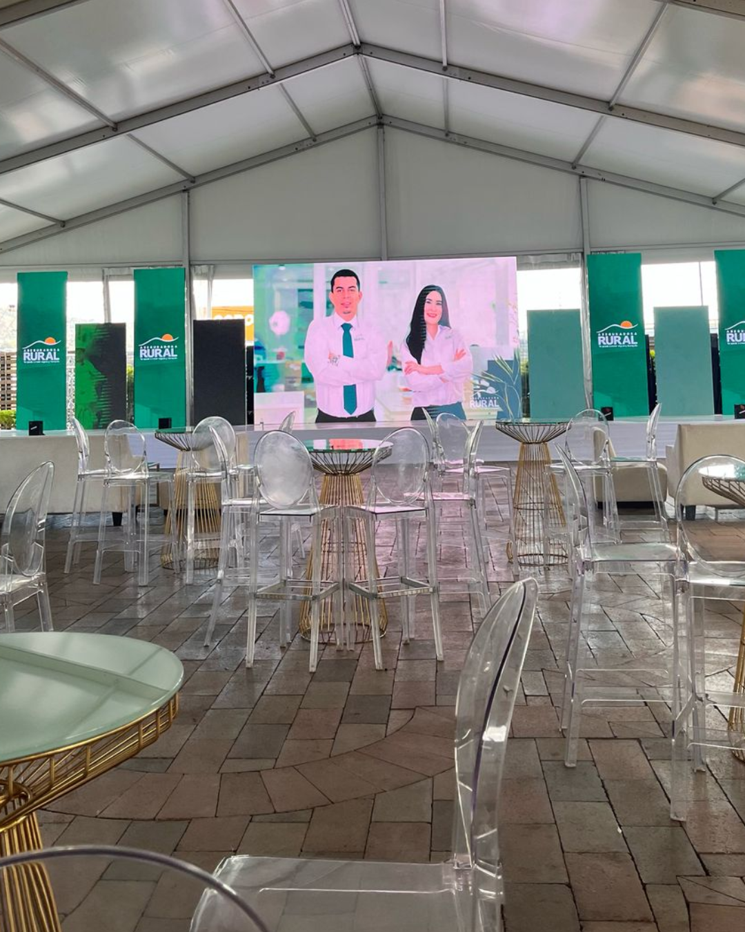 Montaje de evento corporativo de Caja Rural en Honduras con pantalla principal, mobiliario transparente y ambientación de marca