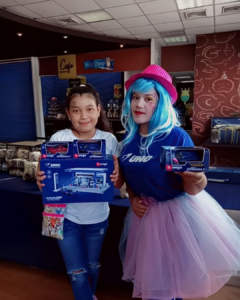 Personaje temático de UNO realizando entrega de premio a un niño durante actividad BTL con interacción promocional