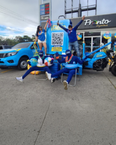 Equipo promocional en dinámica BTL de verano en estación de servicio UNO con material publicitario