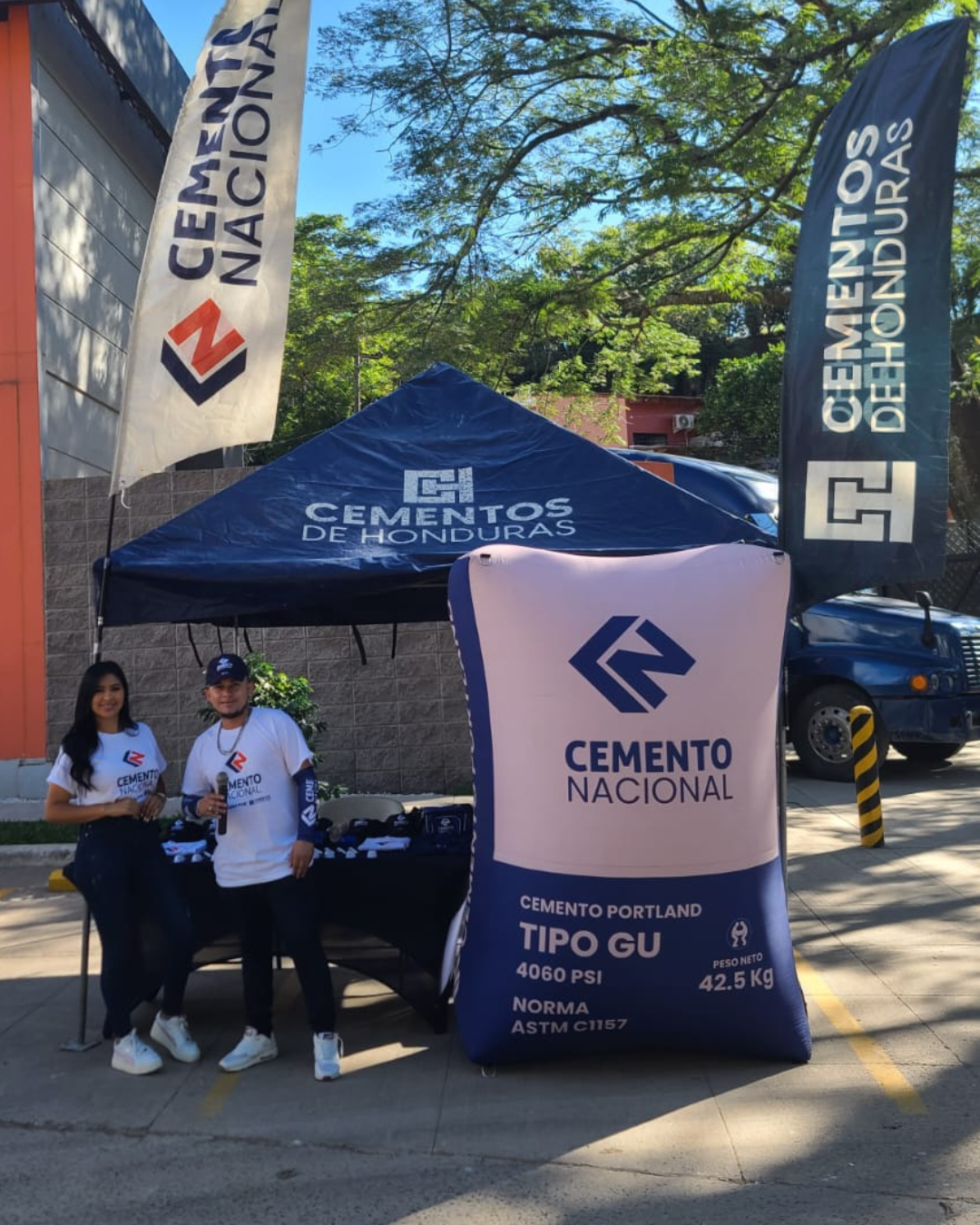 Stand exterior de Cemento Nacional con carpa, banner y banderas publicitarias en punto de activación.