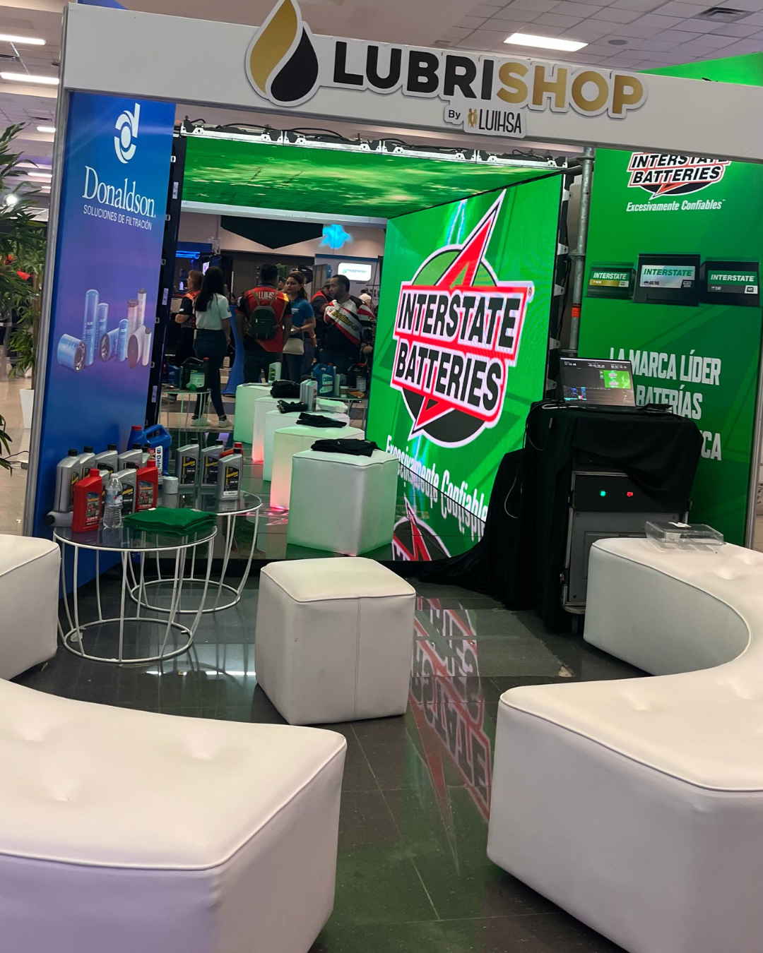 Stand de Lubrishop en una feria corporativa en Honduras con área lounge y exhibición de marca