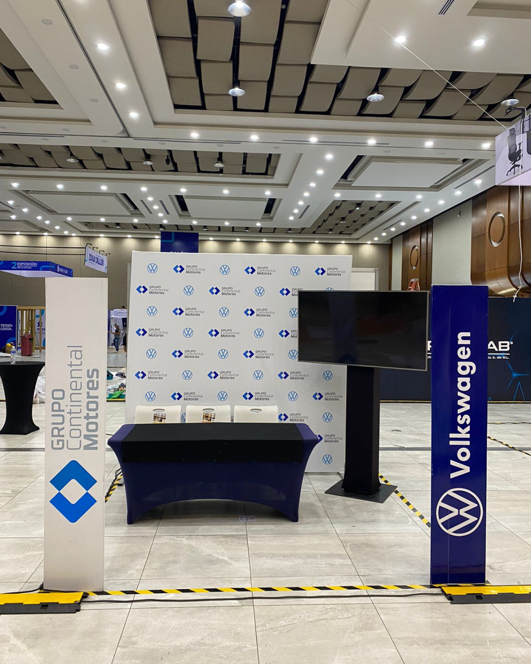 Montaje promocional Volkswagen en evento empresarial con material promocional y espacio de exhibición interior